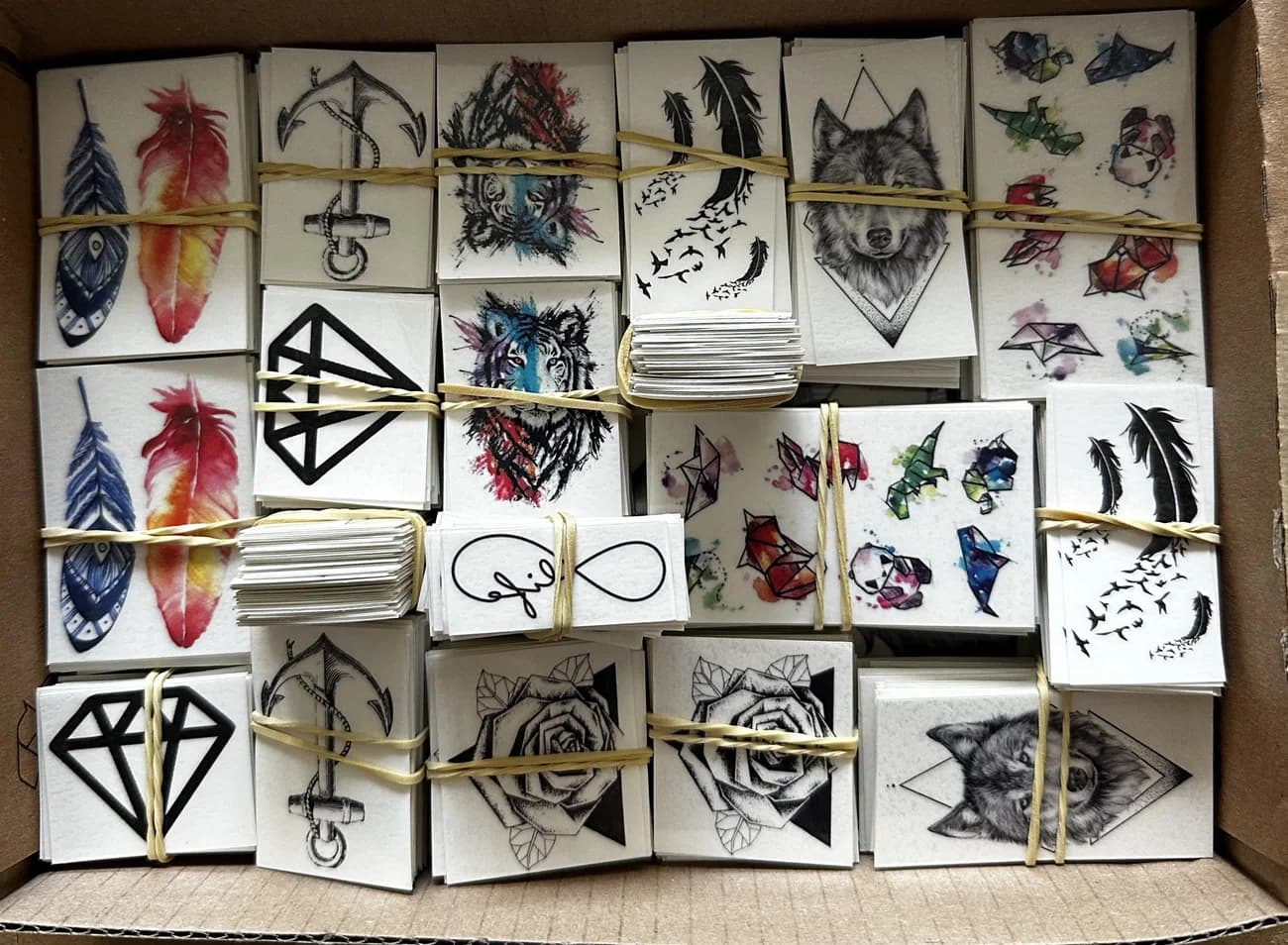Box of premium black-and-grey temporary tattoo designs