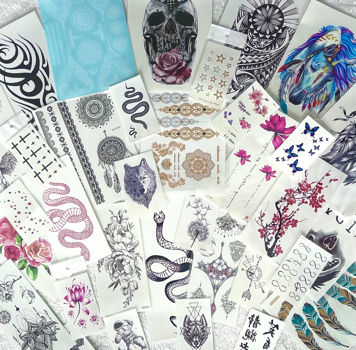 Flat-lay of dozens of temporary tattoo sheets across many styles